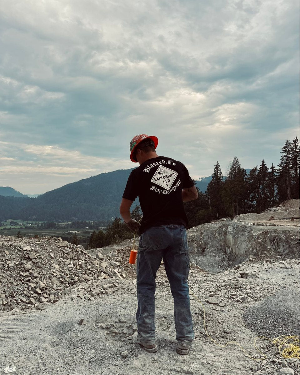 Blasted.Co Stay Dangerous t-shirt worn on a blast site