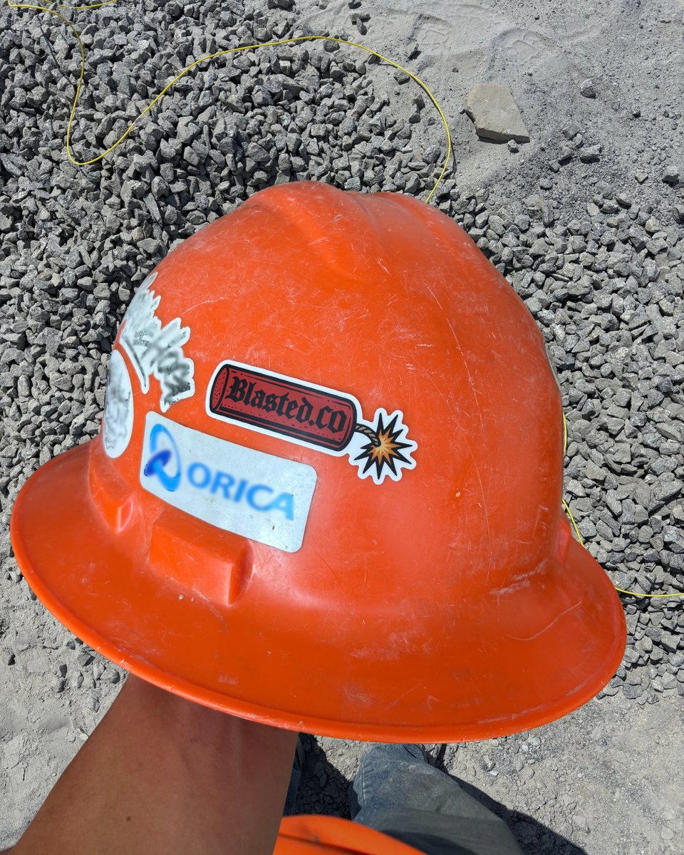 Orange hard hat with a Blasted.Co sticker