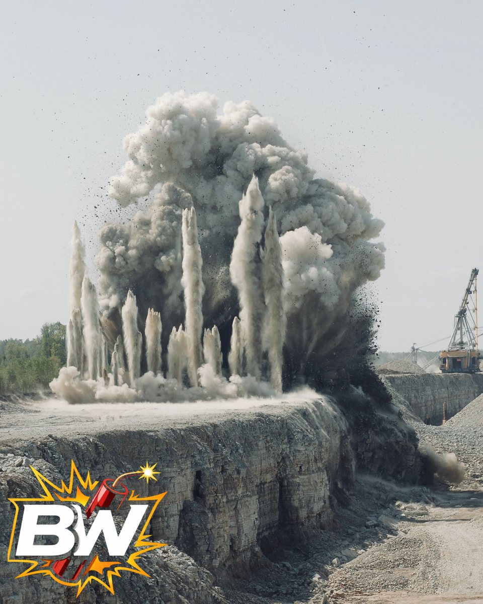 Quarry blast detonating, rock and dust in the air